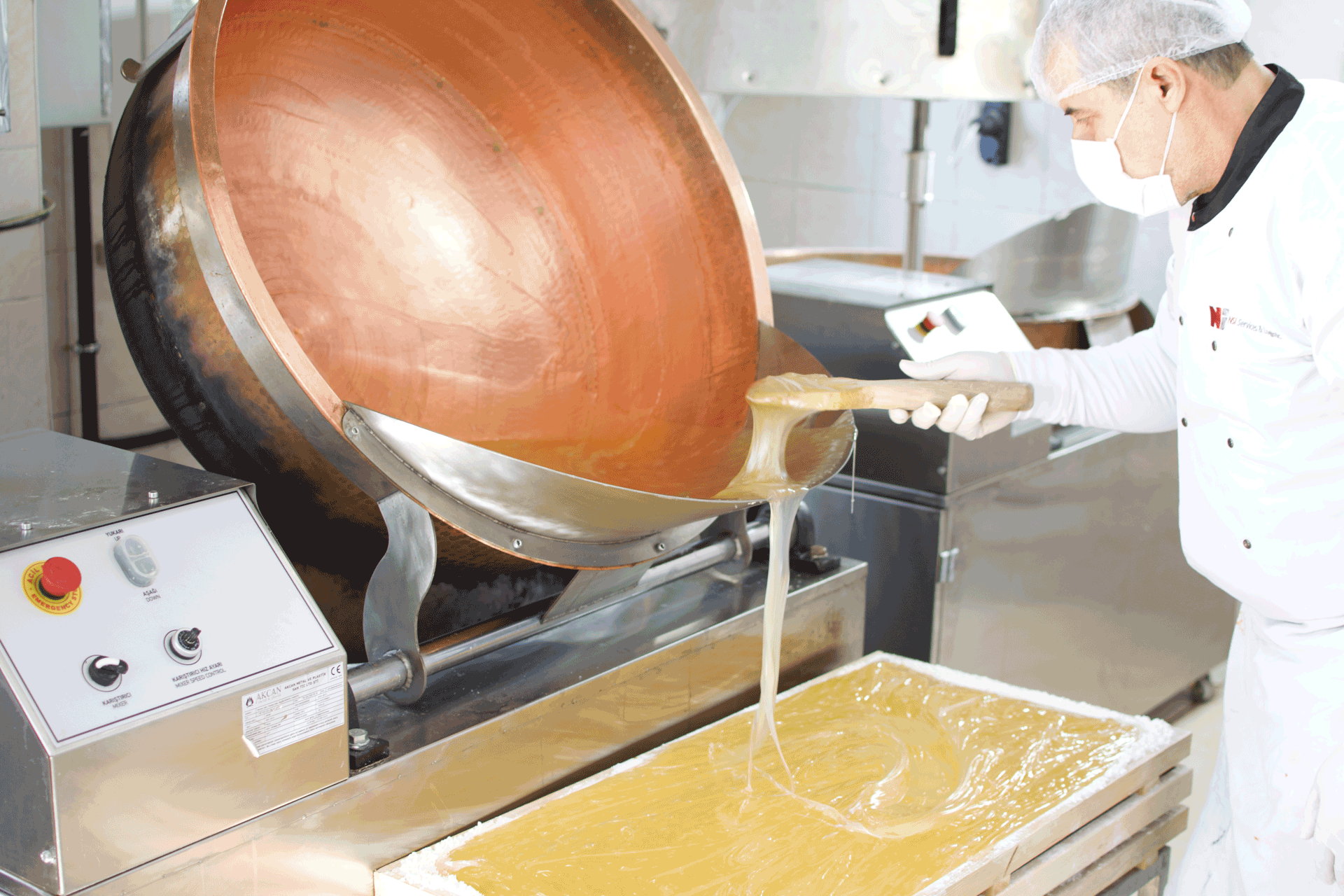 Confectionery mixture poured from a copper kettle into a Turkish delight tray